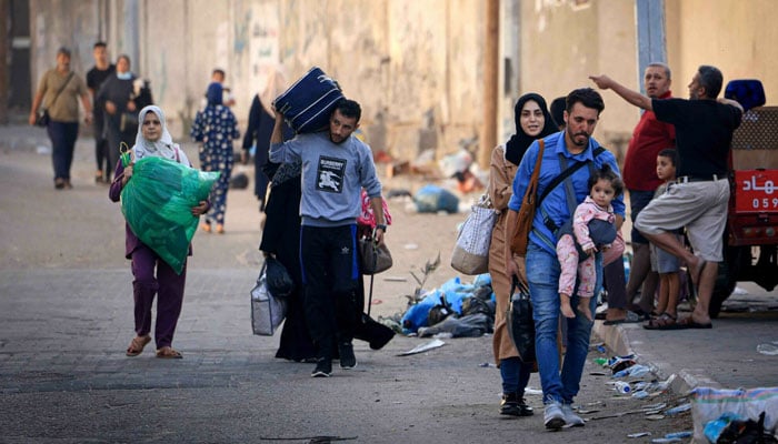 Palestinians with their belongings flee to safer areas in Gaza City after Israeli air strikes, on October 13. AFP/File