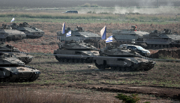 Israeli troops in tanks and other armoured vehicles amass in a field near the southern Israeli city of Ashkelon on October 14, 2023. — AFP