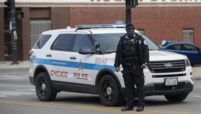 A Chicago Police officer monitors the scene after a shooting in Chicago, Illinois, on March 14, 2021. — AFP