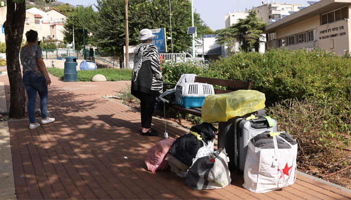 People with their luggage wait in the northern Israeli town of Kiryat Shmona on the border with Lebanon, to be evacuated to a safer location on October 22, 2023.—AFP