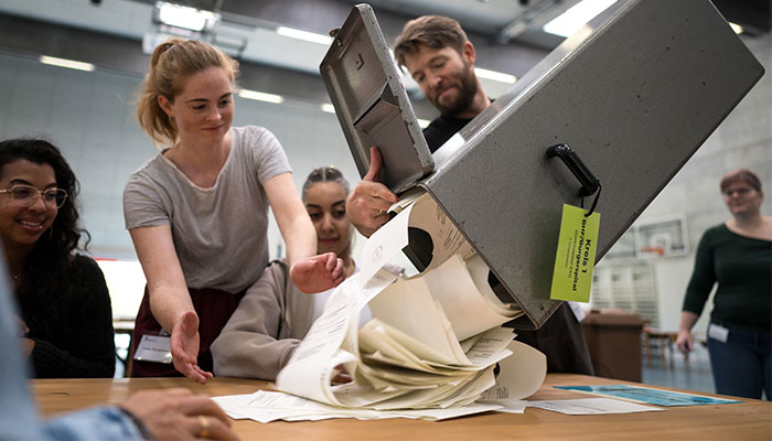 Electoral workers empty a ballot box as counting operations are underway during Swiss federal elections to elect a new Parliament, in Bern, Swiss capital on October 22, 2023.—AFP