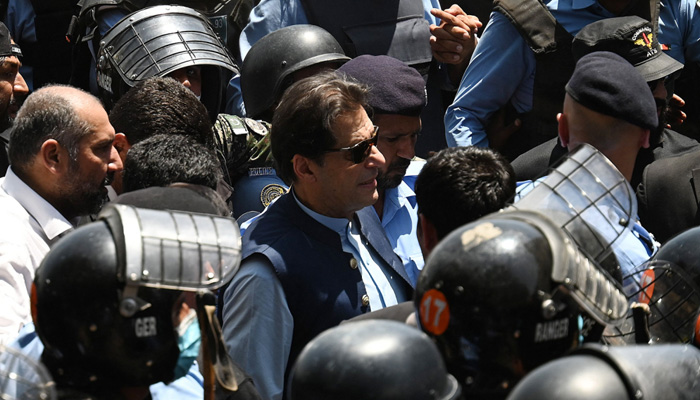 Police commandos escort former Pakistans Prime Minister Imran Khan (centre) as he arrives at the high court in Islamabad on May 12, 2023. — AFP