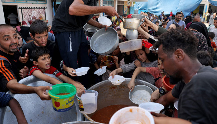 Palestinian children receive food at a United Nations school in Rafah, on the southern Gaza Strip on October 23, 2023. — AFP