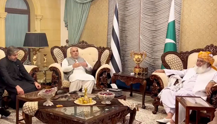 PTIs senior leader Asad Qaiser (left) during the meeting with JUI-F chief Maulana Fazlur Rehman in Islamabad, on October 26, 2023, in this still taken from a video. — X/@juipakofficial