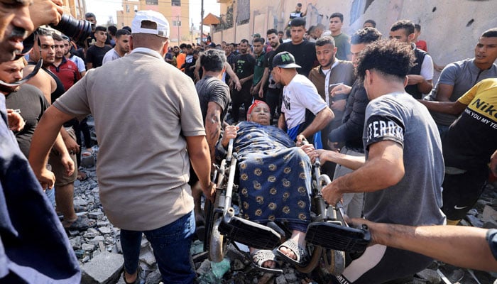 A Palestinian woman is lifted away in her wheelchair following an Israeli air strike on Khan Yunis in the southern Gaza Strip on November 3, 2023, amid the ongoing battles between Israel and Hamas. — AFP