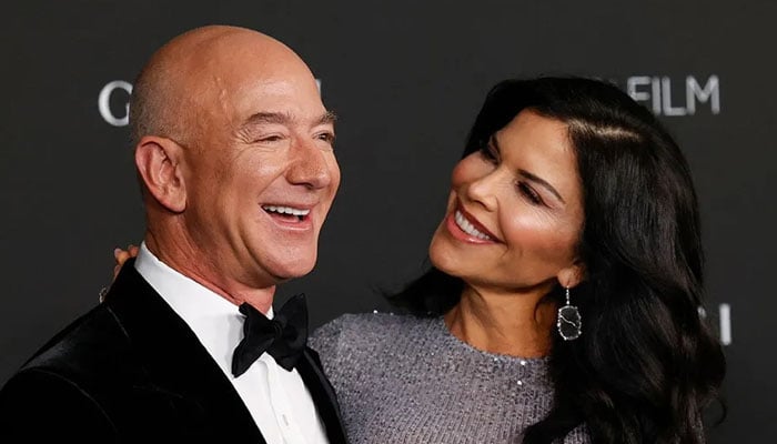 Lauren Sanchez and Jeff Bezos gesture during a gathering. — AFP/File