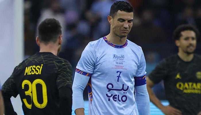 Riyadh All-Stars Portuguese forward Cristiano Ronaldo (centre) walks past Paris Saint-Germain´s Argentine forward Lionel Messi (left) during the Riyadh Season Cup football match between the Riyadh All-Stars and Paris Saint-Germain at the King Fahd Stadium in Riyadh on January 19, 2023. — AFP