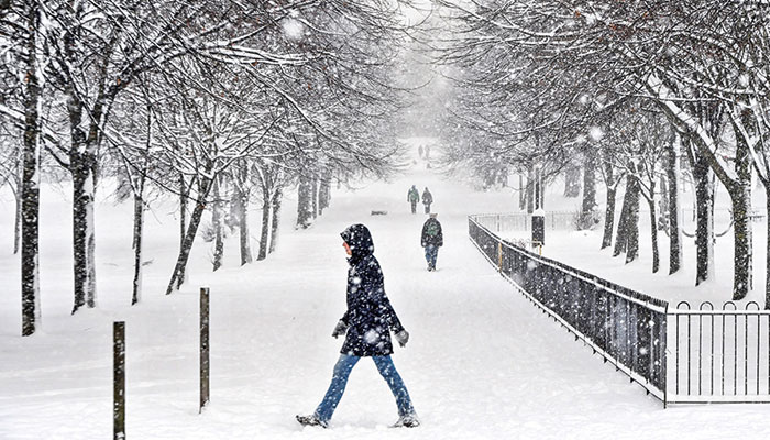 People walk through the snow in Victoria Park in Glasgow on February 9, 2021. —AFP