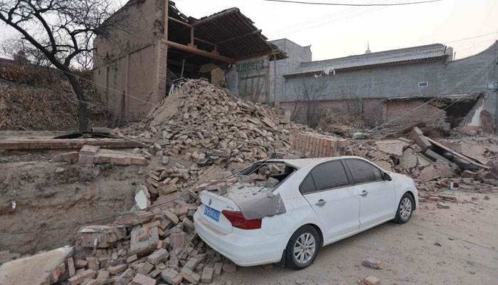 Collapsed buildings and a damaged car are seen after an earthquake in Dahejia, Jishishan County, in northwest Chinas Gansu province on December 19, 2023. — AFP