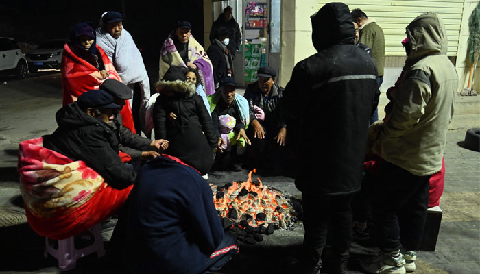 Residents keep warm around fires after an earthquake in Jishishan County, in northwest Chinas Gansu province on December 19, 2023. — AFP