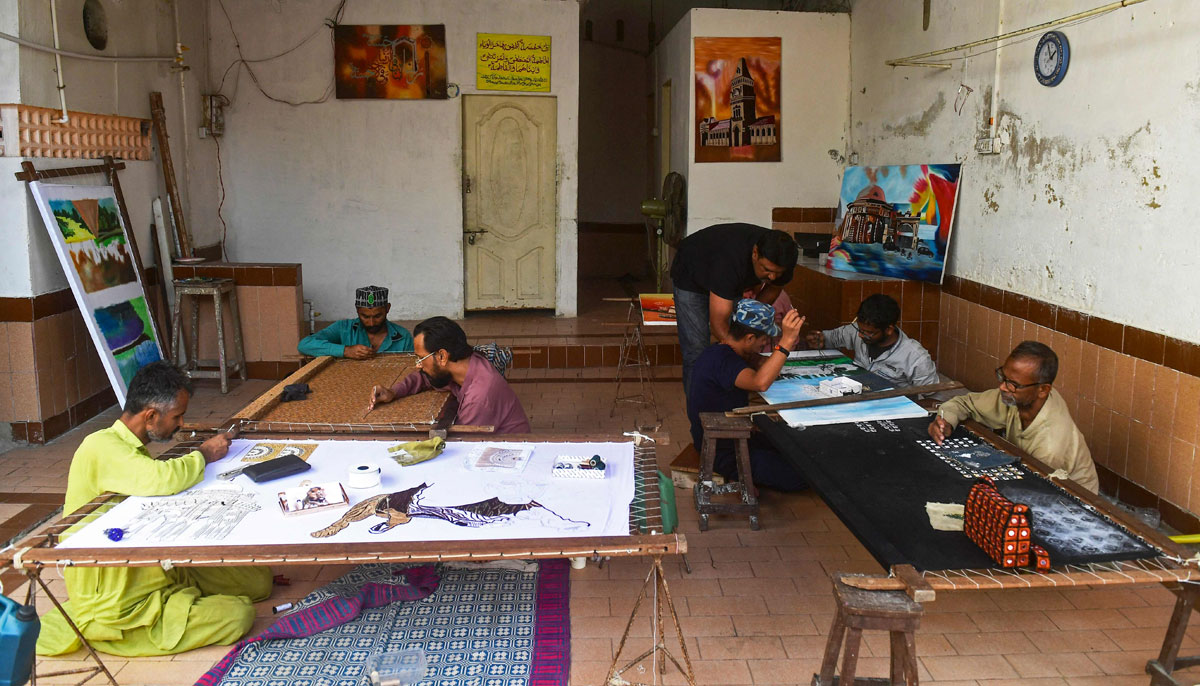 Mohammad Ijaz (3R), an artist and a former convict, guides his students at the central jail in Karachi on December 16, 2023. — AFP