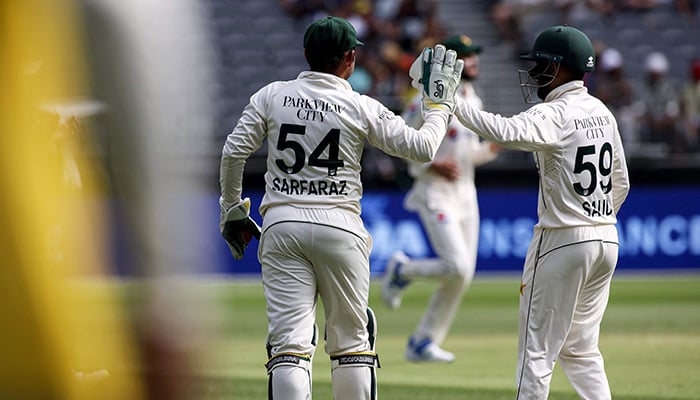 Pakistans Saud Shakeel (right) congratulates teammate Sarfaraz Ahmed after the latter caught a shot by Australias Marnus Labuschagne during day three of the first Test cricket match between Australia and Pakistan in Perth on December 16, 2023. — AFP