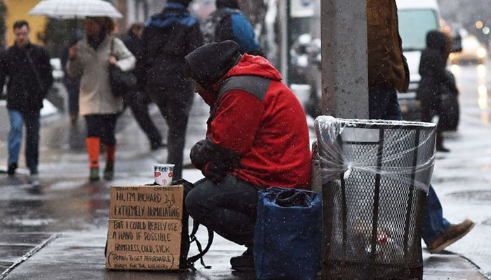 A person sitting on a street in England. — AFP/File