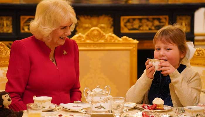 Queen Camilla enjoys a special Christmas tea with a blind schoolgirl with a brain tumour