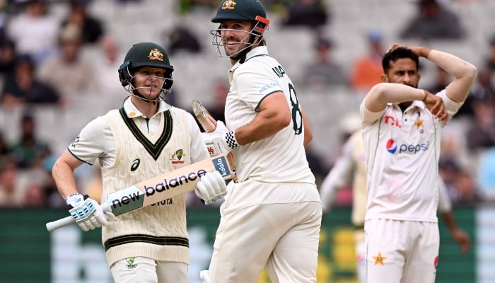 Steve Smith (L) and Mitch Marsh (C) take runs from Hasan Ali (R) on the third day of the second cricket Test match between Australia and Pakistan at the Melbourne Cricket Ground (MCG) in Melbourne on December 28, 2023. — AFP