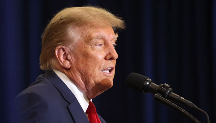 Former President Trump speaks to guests at a campaign event on Dec. 19 in Waterloo, Iowa. — AFP