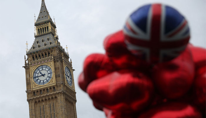 Balloons, one in the colours of the Union flag, are pictured near The Elizabeth Tower, commonly known by the name of the clock´s bell, Big Ben, at the Palace of Westminster, home to the Houses of Parliament, in central London on March 6, 2023. — AFP