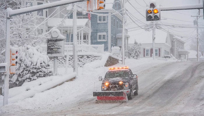 A snowplow clears snow from Broadway in Methuen, Massachusetts on January 7, 2024. — AFP