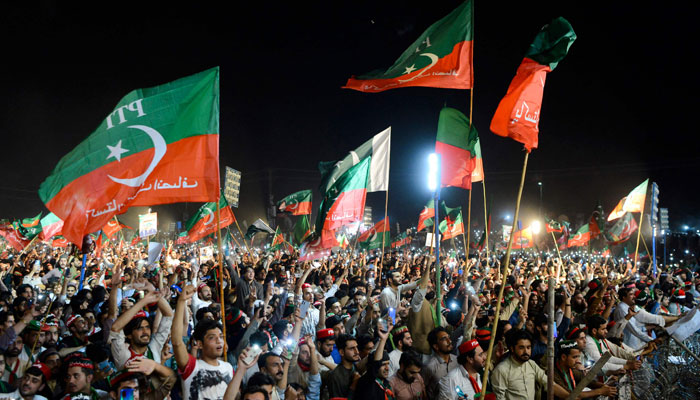 PTI supporters hoist party flags at a public rally in this undisclosed date. — AFP/File