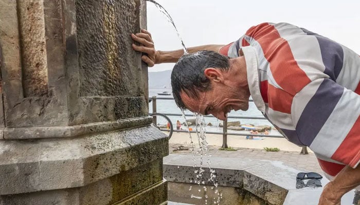 A man cools down in Messina, Sicily, on August 11, 2021. — AFP