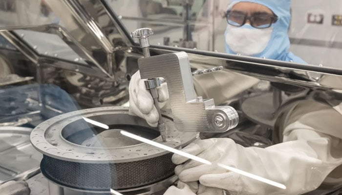 The image shows the OSIRIS-REx curation team attempting to remove one of the fasteners that prohibited the complete opening of the TAGSAM sample head on January 10, 2024. — Nasa