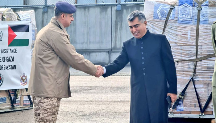Pakistan'ın Ürdün büyükelçisi (sağda) ve Ürdün hava genelkurmay başkanı, Ürdün'deki bir havaalanında İslamabad'dan dördüncü yardım malzemesi sevkiyatını aldıktan sonra el sıkışırken.  — X/@ndmapk