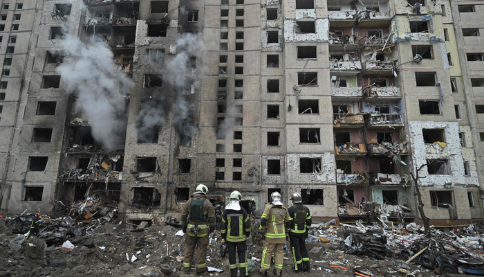İtfaiyeciler, 2 Ocak 2024'te Kiev'in merkezindeki füze saldırısı sonucu yıkılan çok katlı bir konut binasında çalışıyor. — AFP
