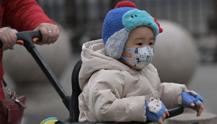 17 Ocak 2024'te Pekin'de bir sokakta yeni yürümeye başlayan bir çocuk görülüyor. —AFP