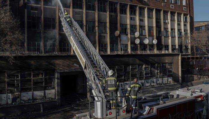 Firefighters extinguish a fire in a building in Johannesburg on August 31, 2023. — AFP