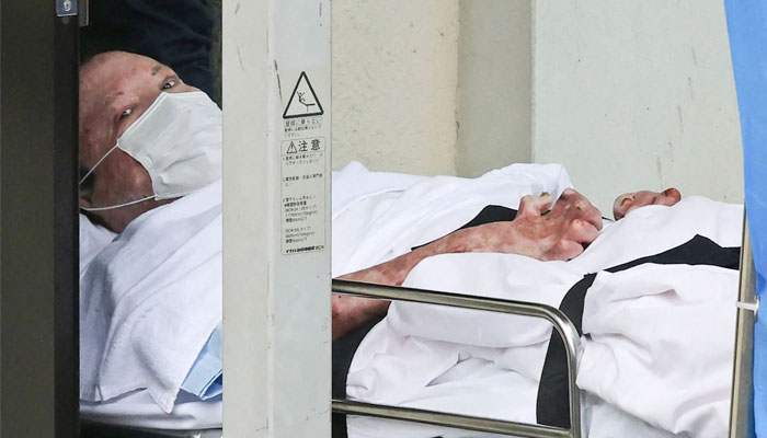 Shinji Aoba is seen on a stretcher as he is carried to Fushimi police station after being arrested in Kyoto, western Japan, on May 27, 2020. — AFP