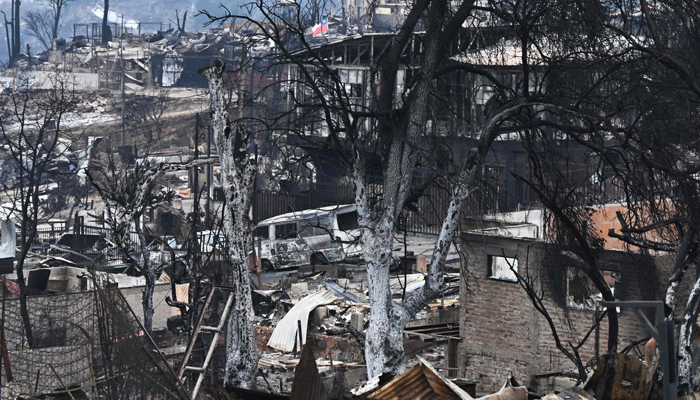 Burned homes and vehicles are seen after a forest fire in Quilpue, Viña del Mar, Chile, on February 4, 2024. — AFP