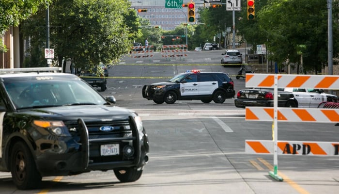 Vehicles of the Texas Police Department can be seen parked on the road as the way is cordoned off. — AFP/File