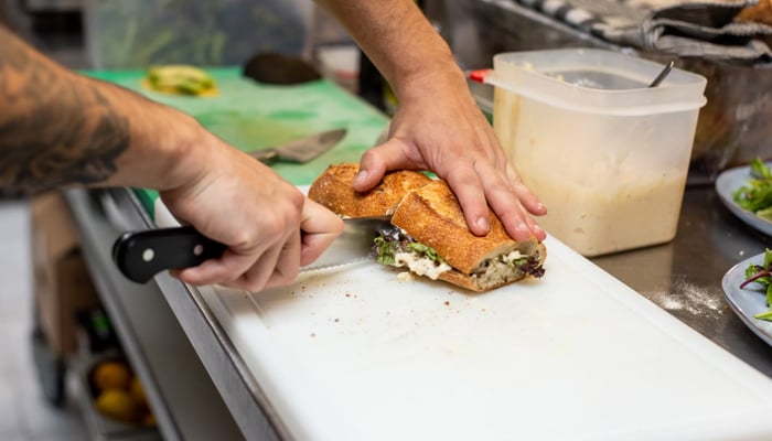 A representational image of a person cutting bread. — Unsplash