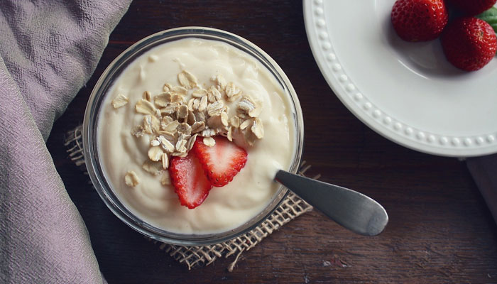 A bowl of Greek yoghurt topped with oats and strawberries. — Pixabay