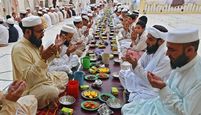 People pray before breaking their fast at a mosque during the first day of Ramadan in Peshawar on July 11, 2013. — AFP