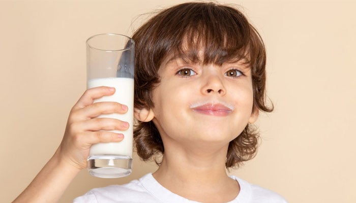 Bir bardak süt tutan bir çocuğun temsili görüntüsü.  — Doğal Gıdalar Asya/Dosya