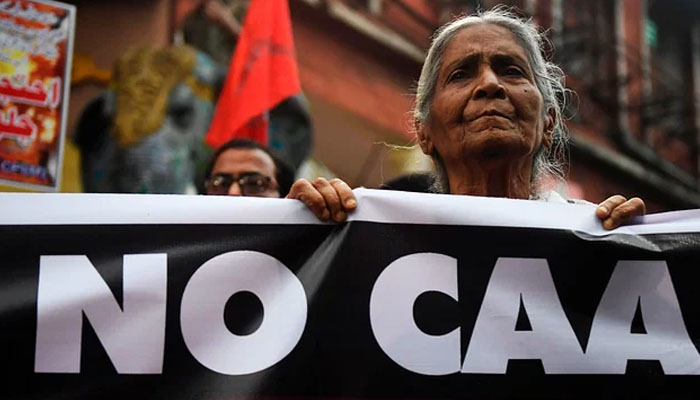 Activist of left parties stand behind a banner during a protest against India`s new citizenship in Kolkata on 26 February 2020, following clashes between people supporting and opposing a contentious amendment to India`s citizenship law in New Delhi. — AFP