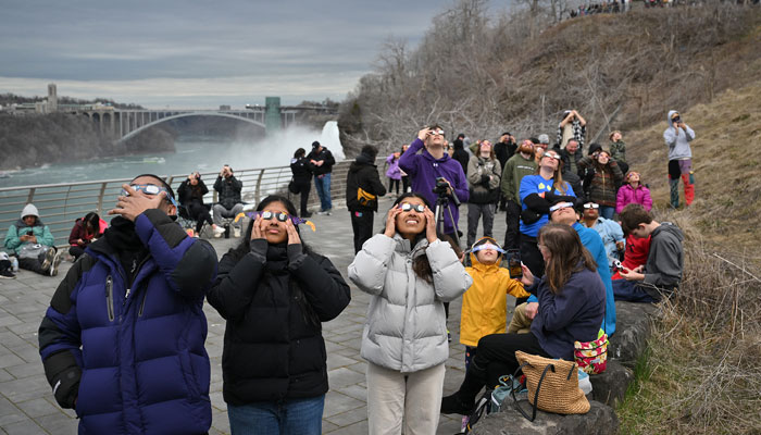 People look up at the sun during the total solar eclipse in Niagara Falls, New York. — AFP