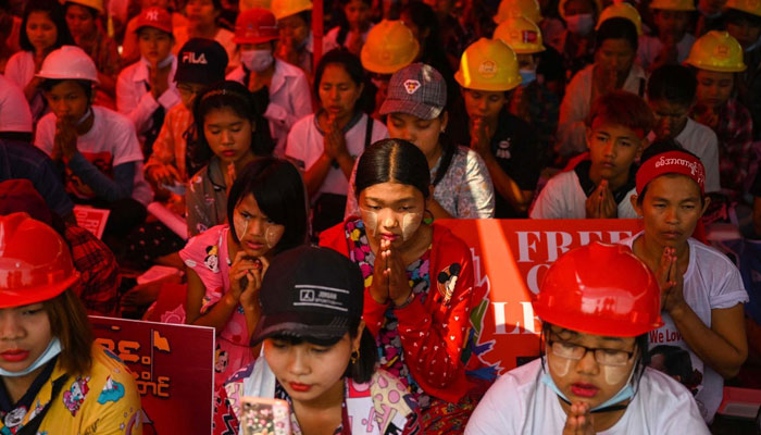 UN report reveals Myanmars middle class vanishing as poverty soars. (Anti-coup protesters pray in Yangon on March 14. — AFP)