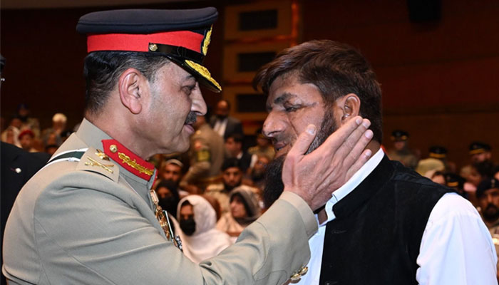 COAS General Asim Munir heartens an attendee at the GHQ Investiture ceremony on May 13, 2024. — X/@PakistanFauj