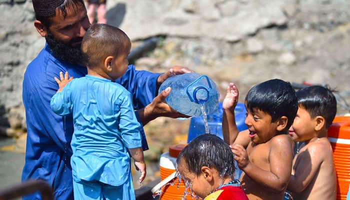 Children enjoying bathing at North Karachi locality during hot weather in Karachi on May 13, 2024. — INP