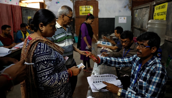 People get their names checked in voters lists inside a polling station during the fifth phase of Indias general election in Howrah district in the eastern state of West Bengal, India, on May 20, 2024. — Reuters