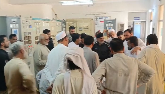 Police officer is seen trying to calm down citizens at the Hazarkhawani grid station in Peshawar on May 25, 2024, in this still taken from a video. — YouTube/Geo News Live