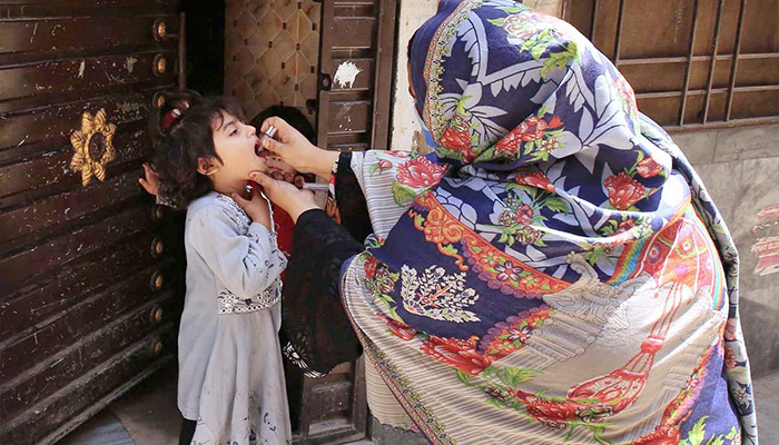 Lady health worker administering polio drops to a child during anti-polio drive at Peshawars Dalazak Road. — APP