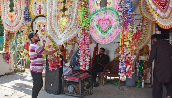 A person is taking interest in traditional garlands used in marriage ceremonies at Aabpara Market in Islamabad on June 20, 2023. — Online