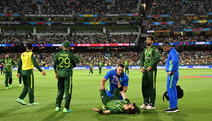Shaheen Shah Afridi (C) lies on the ground as he receives treatment after injury during the ICC mens Twenty20 World Cup 2022 final, England vs Pakistan, Melbourne Cricket Ground (MCG), November 13, 2022. — AFP
