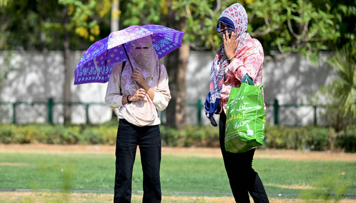 Women wearing scarves walk in a garden on a hot summer day in New Delhi on May 30, 2024, amid ongoing heatwave. India is enduring a crushing heatwave with temperatures in several cities sizzling well above 45 degrees Celsius. — AFP