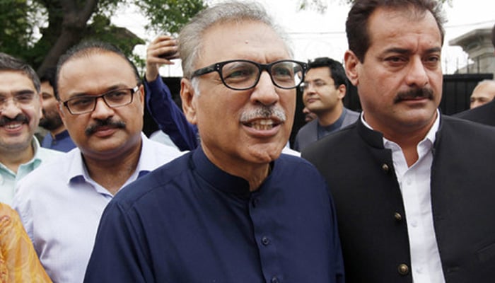 PTI leader Arif Alvi (C) walks back with party leaders after submitting papers for the presidential election outside the high court building in Islamabad. — AFP/File