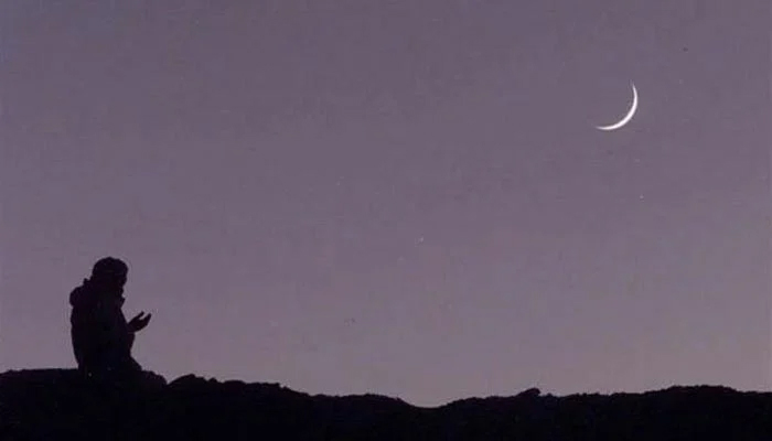 An undated image of a person praying while seeing the moon. — AFP/File