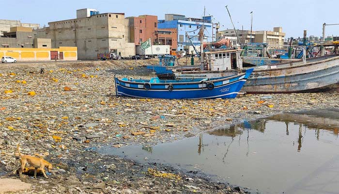 A view of a boat stuck in fisheries area due to garbage in Karachi on June 5, 2024. — INP